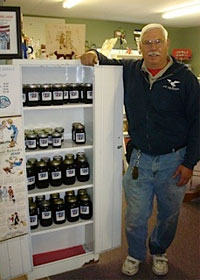 Mack Gunnlaugsson and his refrigerator full of maple syrup. – Photo by Melissa Walker
